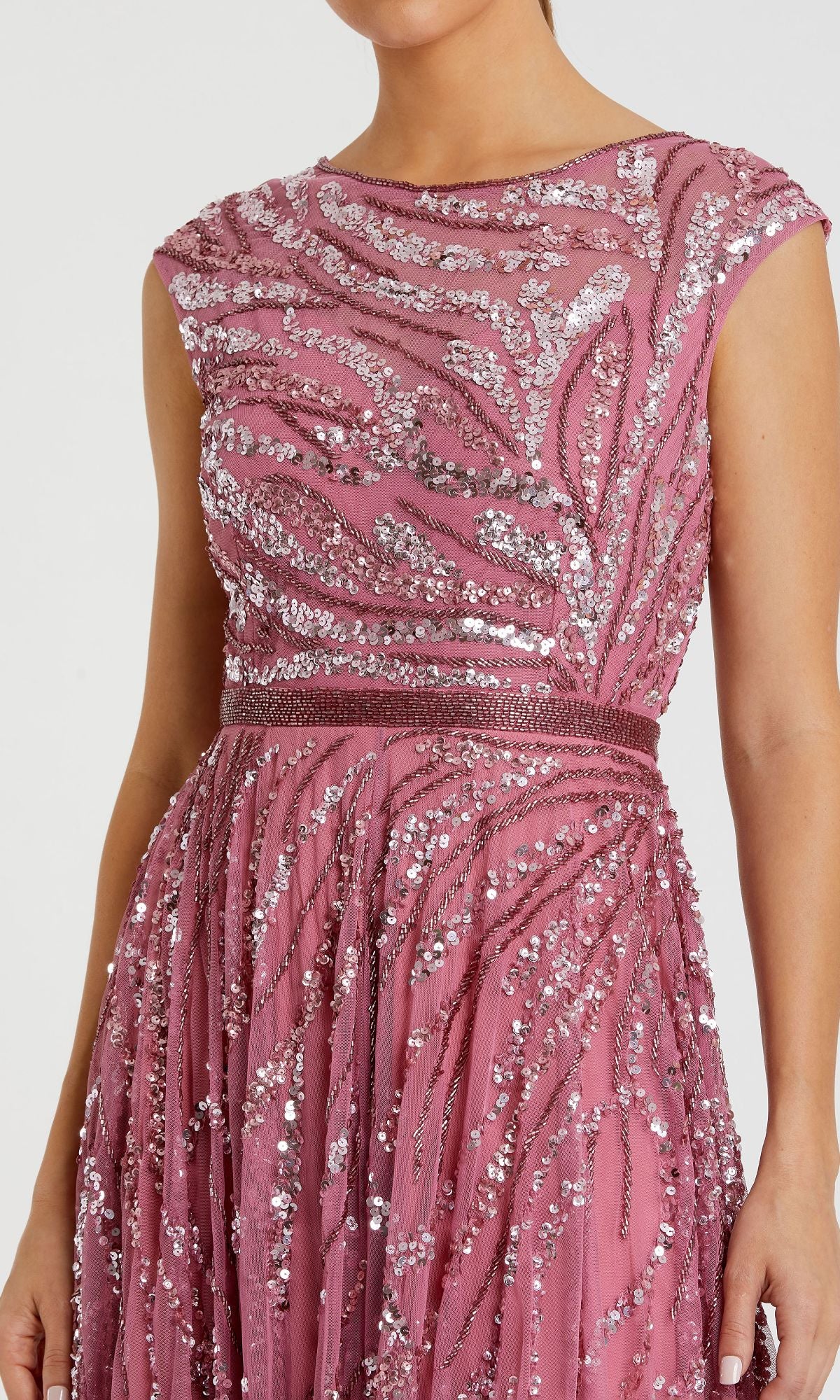 A woman wearing the Mac Duggal 5445 high-neck beaded formal gown, a sleeveless pink dress featuring silver sequin embellishments in a wavy pattern.
